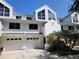 Attractive two-story townhouse featuring a white exterior, attached garage and manicured landscaping at 9914 Indian Key Trl # 32, Seminole, FL 33776