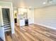Open living space features plank flooring, a kitchenette and easy access to the stairs at 9914 Indian Key Trl # 32, Seminole, FL 33776