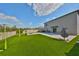 Expansive backyard with manicured artificial turf, a soccer net, fire pit, and outdoor seating at 10112 Rose Petal Pl, Riverview, FL 33578