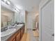 Bathroom with double sinks, granite countertops, large mirror, tiled floors, and updated fixtures at 10112 Rose Petal Pl, Riverview, FL 33578