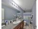 Bathroom features granite counters, a large mirror, good lighting, and a shower with a blue and white curtain at 10112 Rose Petal Pl, Riverview, FL 33578