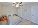 Bedroom with carpet, ceiling fan, white walls, closet, gray bedding, and bedside tables with orange drawers at 10112 Rose Petal Pl, Riverview, FL 33578