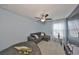 Blue Bedroom with ceiling fan, carpet, white curtains, and a gray sectional sofa with pillows at 10112 Rose Petal Pl, Riverview, FL 33578