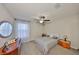 Bedroom with carpet, modern ceiling fan, round mirror, white curtains, and a bed with neutral-colored bedding at 10112 Rose Petal Pl, Riverview, FL 33578