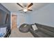 Blue Bedroom with ceiling fan, carpet, gray sectional sofa with pillows and adjacent to a hallway at 10112 Rose Petal Pl, Riverview, FL 33578