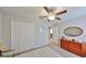 Bedroom featuring carpet, ceiling fan, double closet doors and adjacent to a full bath at 10112 Rose Petal Pl, Riverview, FL 33578