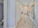 Hallway with tile floors, white trim, an adjacent bathroom, and a front door view at 10112 Rose Petal Pl, Riverview, FL 33578