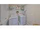 Laundry room features washer, dryer, shelf with decor, and tile floor at 10112 Rose Petal Pl, Riverview, FL 33578