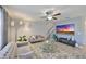 Living room with a ceiling fan, television, plush sofas, and tile flooring at 10112 Rose Petal Pl, Riverview, FL 33578