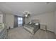 Relaxing main bedroom offers plush carpet, ceiling fan, dresser, and stylish bedframe with tufted headboard at 10112 Rose Petal Pl, Riverview, FL 33578