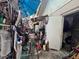 Exterior view of the backyard, revealing a pathway overwhelmed with cluttered and disorganized items and debris at 12588 128Th Ave, Largo, FL 33774