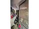 Interior room filled with disorganized items and debris, viewed through an open doorway with a screen at 12588 128Th Ave, Largo, FL 33774