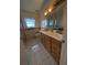 Bright bathroom featuring double vanity, framed mirror, and natural light from window at 13913 Dominica Dr, Seminole, FL 33776