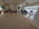 Bright living room featuring tile flooring, ceiling fan, and large windows overlooking the pool area at 13913 Dominica Dr, Seminole, FL 33776