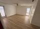 Bright living room with wood-look floors, ceiling fan, window and sliding glass door for lots of light at 13986 Bonnie Brae Dr, Largo, FL 33774