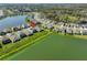 Aerial view of a neighborhood, featuring a house with solar panels, and a beautiful lake nearby at 1407 Tropical Oasis Ave, Plant City, FL 33565