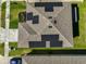 Aerial view of a house roof featuring solar panels, surrounded by a well-maintained lawn and driveway at 1407 Tropical Oasis Ave, Plant City, FL 33565