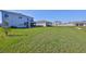 Expansive backyard featuring lush green grass and a covered patio, perfect for outdoor relaxation at 1407 Tropical Oasis Ave, Plant City, FL 33565