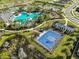 Aerial view featuring a pool, playground, and basketball court in a lush community at 1407 Tropical Oasis Ave, Plant City, FL 33565