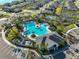 Aerial view of community pool, playground, and tennis courts nestled among palm trees at 1407 Tropical Oasis Ave, Plant City, FL 33565