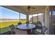 Relaxing screened-in patio features a ceiling fan, dining table, and peaceful views of the nearby lake at 1407 Tropical Oasis Ave, Plant City, FL 33565