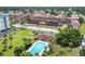 Aerial view of a complex with manicured grounds featuring a community pool, lush landscaping, and ample parking at 14834 Crown Dr, Largo, FL 33774