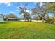 A spacious backyard features mature trees, a white fence, and a screened-in pool at 1707 Sunnyhills Dr, Brandon, FL 33510