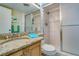 Bathroom featuring a granite countertop, toilet, and a shower with sliding glass doors at 17580 Gulf Blvd # 302, Redington Shores, FL 33708