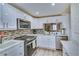 Well-lit kitchen featuring sleek, white cabinets, stainless steel appliances, and tile backsplash at 17580 Gulf Blvd # 302, Redington Shores, FL 33708