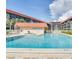 Community pool surrounded by lounge chairs, lush landscaping, and multi-story condos at 17580 Gulf Blvd # 302, Redington Shores, FL 33708
