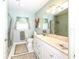 Bathroom with blue square tiled walls, neutral shower curtain and flooring, and a large mirror above the sink at 2215 River Ridge Dr, Sarasota, FL 34239