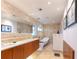 Bright bathroom featuring stone tiles, soaker tub, modern fixtures, and double vanity with ample counter space at 2215 River Ridge Dr, Sarasota, FL 34239