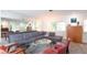 Bright and airy living room featuring a plush grey sofa, mirrored wall, modern art, and wood-look flooring at 2215 River Ridge Dr, Sarasota, FL 34239