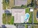 Aerial view of a home with a kidney shaped pool, a large yard, and a white fence at 2216 Mcmullen Rd, Largo, FL 33771