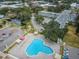 Aerial showcases condo complex with a clover pool surrounded by patios, parking, and community green spaces at 2430 Florentine Way # 44, Clearwater, FL 33763