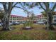 Apartment building exterior with a large lawn, trees, and parking at 2430 Florentine Way # 44, Clearwater, FL 33763