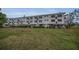 View of the rear of a multi-unit apartment building with well-maintained green space at 2430 Florentine Way # 44, Clearwater, FL 33763