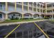 Exterior view of multi-story condo building with covered parking and lush landscaping around building at 2430 Florentine Way # 44, Clearwater, FL 33763