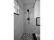 Close up of shower featuring grey tiled walls, pebble floor, and black hardware at 2430 Florentine Way # 44, Clearwater, FL 33763