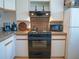 Efficient kitchen showcasing stainless steel appliances, neutral cabinets, and tiled backsplash at 3001 58Th S Ave # 312, St Petersburg, FL 33712