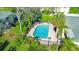 An aerial shot of the community pool area, surrounded by lush greenery and lounge chairs at 3001 58Th S Ave # 312, St Petersburg, FL 33712