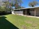 Spacious backyard featuring a well-maintained lawn, screened lanai, and lush landscaping providing privacy at 36416 Cordova Cir, Zephyrhills, FL 33541