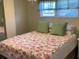 Cozy bedroom featuring a floral patterned comforter and bright natural light at 36416 Cordova Cir, Zephyrhills, FL 33541