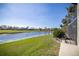 Peaceful backyard view with serene pond and lush green lawn at 4906 Turtle Creek Trl, Oldsmar, FL 34677