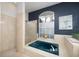 Bright bathroom area with large tub, shower, and frosted windows for privacy at 4906 Turtle Creek Trl, Oldsmar, FL 34677