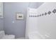 This bathroom showcases a tiled shower with decorative trim and a framed artwork at 4906 Turtle Creek Trl, Oldsmar, FL 34677