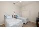 Bright, cozy bedroom featuring two beds, a ceiling fan, and wood-look flooring at 4906 Turtle Creek Trl, Oldsmar, FL 34677