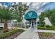 Inviting clubhouse entrance with a decorative awning, surrounded by well-maintained landscaping at 4906 Turtle Creek Trl, Oldsmar, FL 34677