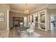 Elegant dining room featuring a glass table, decorative shelving, and a stylish chandelier at 4906 Turtle Creek Trl, Oldsmar, FL 34677