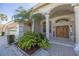 Inviting front entrance featuring double doors and lush tropical landscaping at 4906 Turtle Creek Trl, Oldsmar, FL 34677